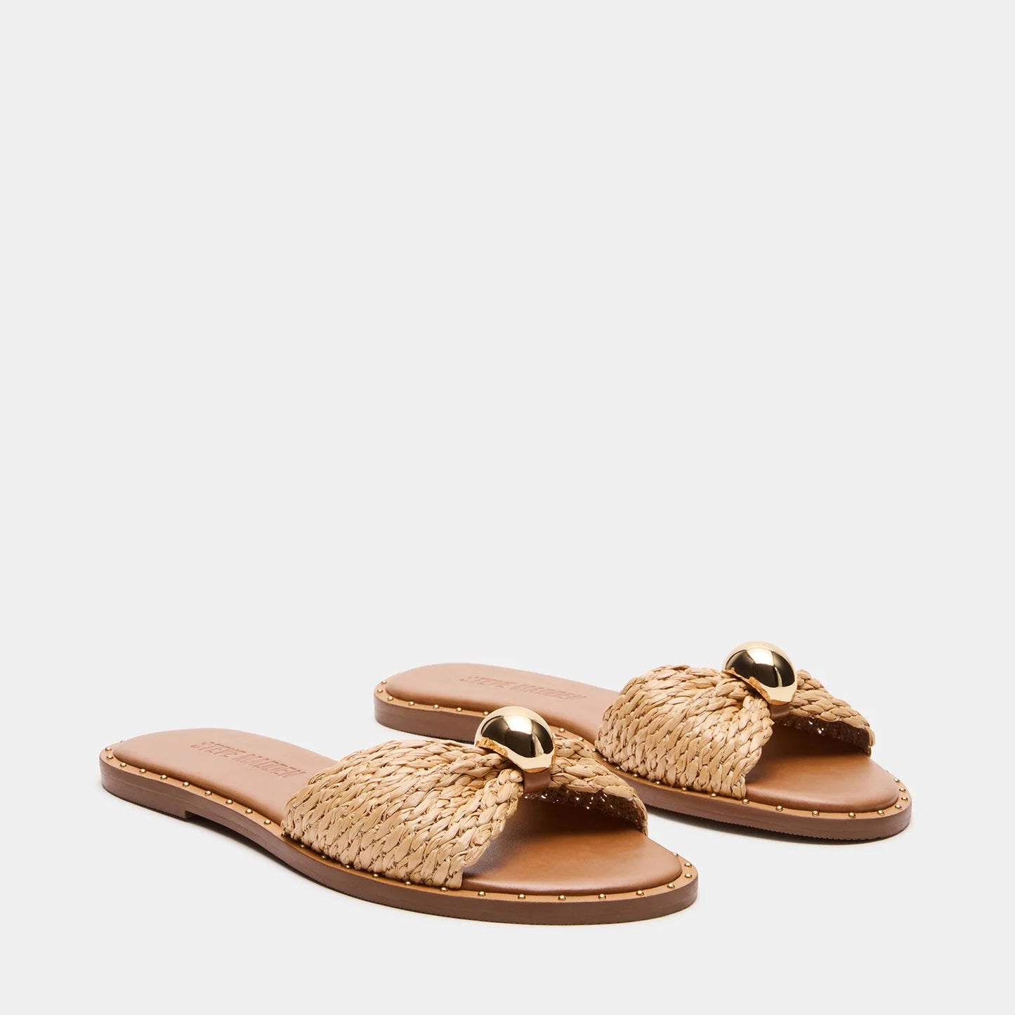 Pair of woven sandals with gold accents on a white background