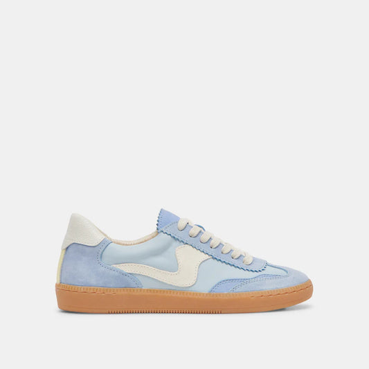 A blue suede sneaker with white lace-up details and a light brown rubber outsole.